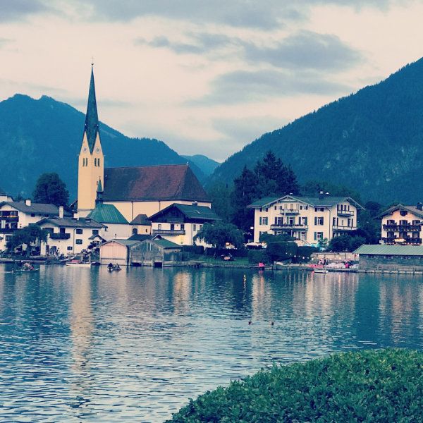 Kirche am See, dahinter Berge