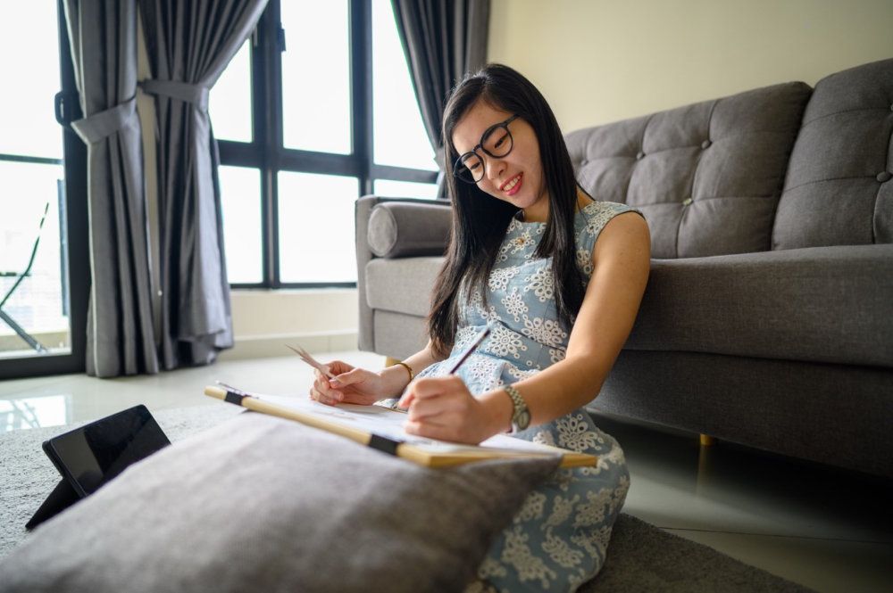 Frau zeichnet mit Kind zusammen